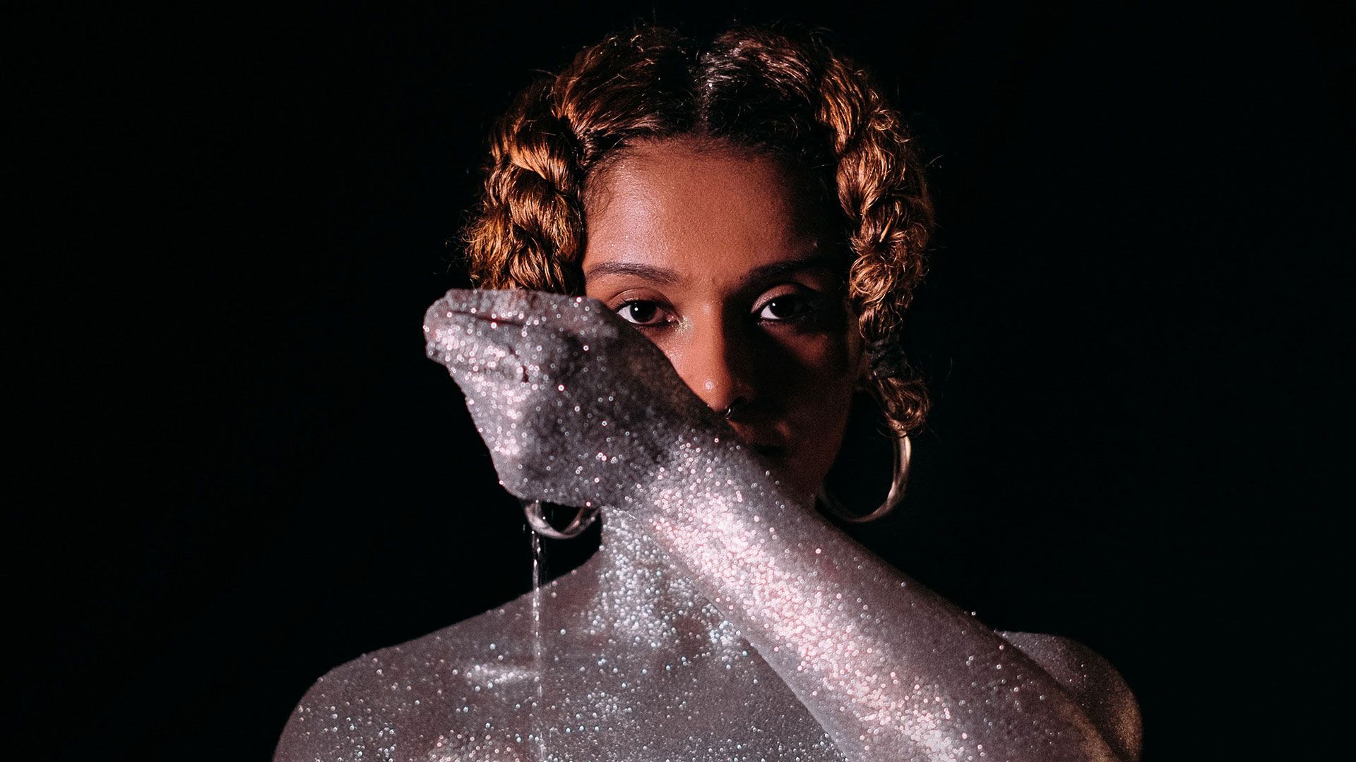 Vemos no vídeo a imagem de uma mulher jovem, em um fundo preto, seus cabelos estão divididos ao meio com duas tranças curtas uma de cada lado da cabeça, vemos seu corpo dos ombros para cima, ela está coberta por glitter prata do pescoço para baixo, seu rosto está limpo no inicio do video e ela usa brincos de argola. Na sequência do vídeo um líquido viscoso e vermelho escorre de sua cabeça e começa a borrar todo seu corpo, ao fim desta sequência close na mão parada coberta pelo líquido, ouvimos ao fundo o hino nacional. A segunda parte do vídeo a mesma mulher aparece desta vez apenas coberta de glitter pra e toca samba ao fundo.